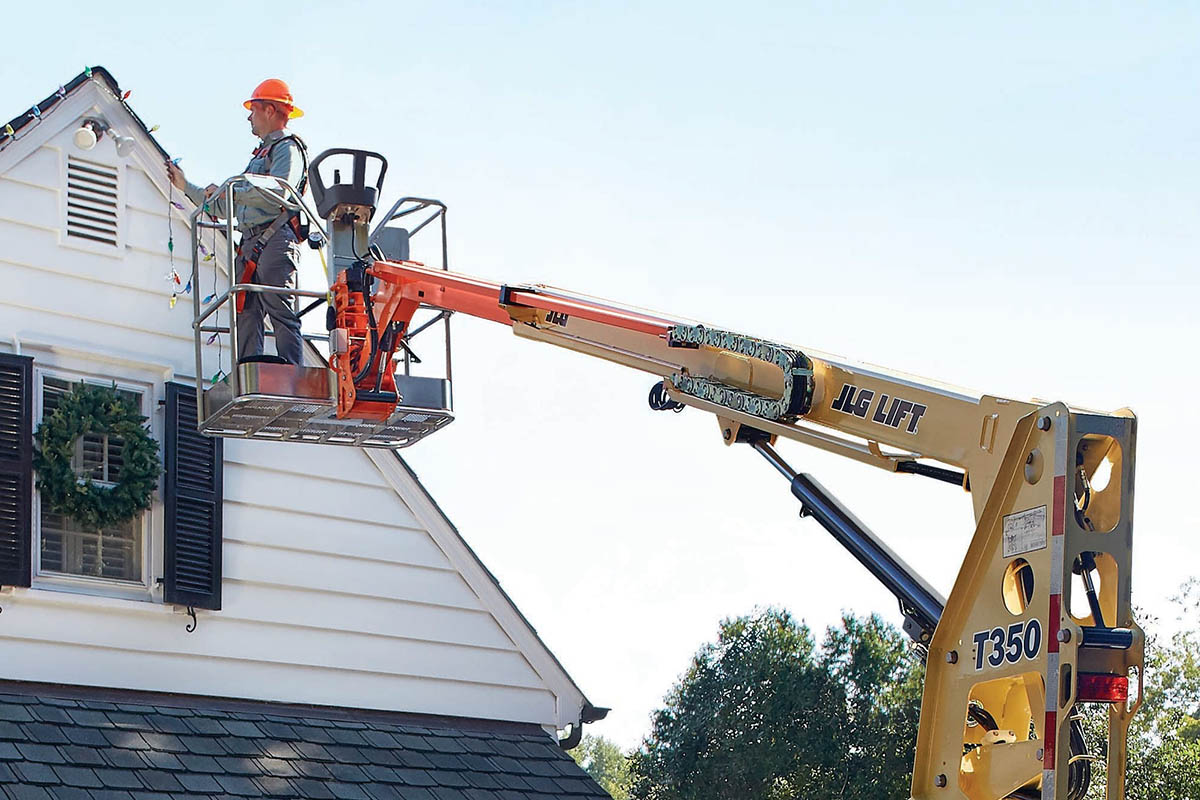 Cẩu nâng người lên cao để tu bổ, trang trí mái nhà